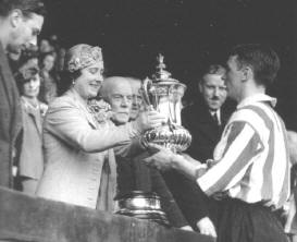 Raich Carter Receives the Cup From The Queen